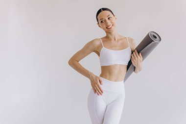 Beyaz arka planda yoga minderi tutan genç kadın panoramik afiş, spor, fitness, meditasyon, yoga dengesi, farkındalık, egzersiz, hobi, sağlıklı yaşam tarzı konsepti