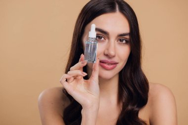 Bej arka planda Serum Bırakan Kadın. Pipette 'ten Serum Kolajeni Nemlendirici kullanan Avrupalı Kız. Yakın plan. Pozitif Gülen Güzel Kadın Portresi. Yüz Cildi Bakımı Konsepti