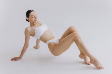 Vücut Güzeli, Beyaz İç Çamaşırlı Sıska Kadın Sırtüstü Uzanıyor, Mutlu Rüya Gören Kız Kopya Alanlı Beyaz Arkaplanda İzole Edildi,