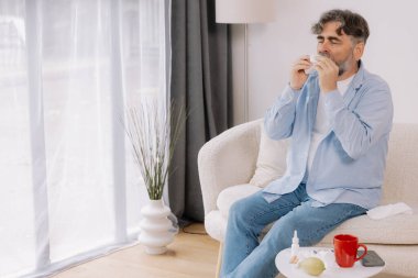 Yaşlı bir adamın mendile hapşırması, soğuk algınlığı veya alerjiden rahatsızlık duyması, mevsimsel alerjiler, virüs, grip ve hasta sağlığı, sağlık durumu, kıdemli bakım ve solunum için tıbbi tedavi