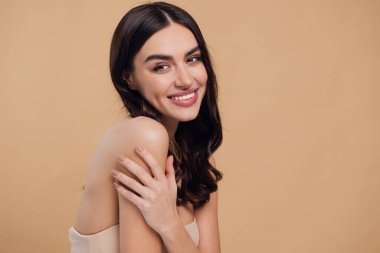 Güzel, genç, esmer, bej arkaplan, yüz bakımı, kozmetik, güzellik ve kaplıca, gülümseyen kadın portresi..