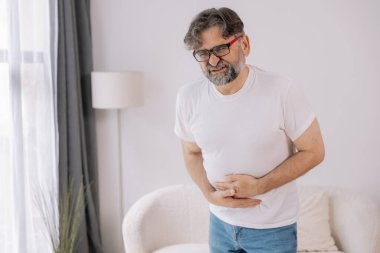 Evde sindirim sorunları, karaciğer ve safra kesesi sorunları ve bağırsak ağrısı çeken yaşlı bir adam var.