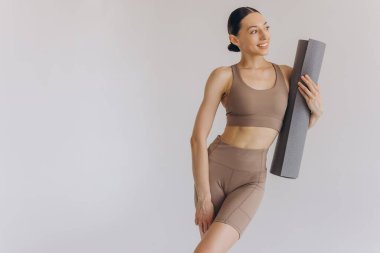 Beyaz arka planda yoga minderi tutan genç kadın panoramik afiş, spor, fitness, meditasyon, yoga dengesi, farkındalık, egzersiz, hobi, sağlıklı yaşam tarzı konsepti