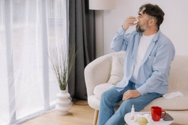 Yaşlı bir adamın mendile hapşırması, soğuk algınlığı veya alerjiden rahatsızlık duyması, mevsimsel alerjiler, virüs, grip ve hasta sağlığı, sağlık durumu, kıdemli bakım ve solunum için tıbbi tedavi