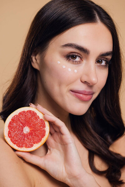 Eye Skin Care Woman. Beautiful Young Woman Holding Grapefruit Applying Eye Cream Drops On Skin Under Eyes. Antiage Treatment Concept. High Quality