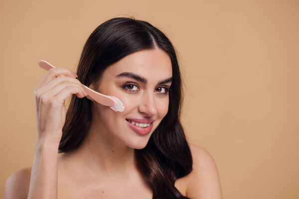 Half naked woman, face and brush cream for beauty, salon and skin care on mock up beige background. Happy model, facial lotion and make up cosmetics for dermatology, collagen and smile of happiness
