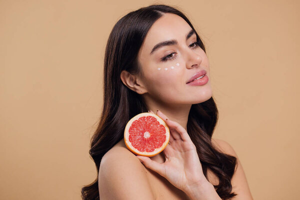 Eye Skin Care Woman. Beautiful Young Woman Holding Grapefruit Applying Eye Cream Drops On Skin Under Eyes. Antiage Treatment Concept. High Quality