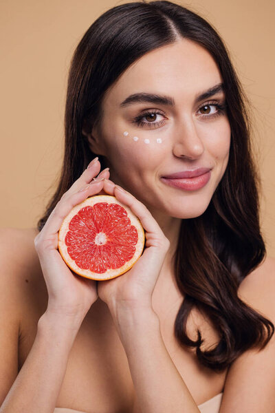 Eye Skin Care Woman. Beautiful Young Woman Holding Grapefruit Applying Eye Cream Drops On Skin Under Eyes. Antiage Treatment Concept. High Quality