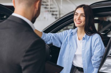 Genç bayan müşteri bayan alıcı, satış elemanı Hold tabletine gömlek danışarak araba galerisi araç galerisi galerisi galerisi araba galerisinde yeni otomobil almak istiyor..