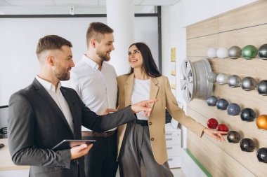 Satıcı, yeni arabaları için bir araba dükkanında doğru rengi seçen bir çifte yardım teklif ediyor. Araba satış işi. Yönetici çiftlerle konuşuyor, galerideki yeni otomobili gösteriyor.