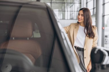 Kadın, portre ve araba galerisine satış, ödeme ve yeni araba alımıyla gülümse. Alışveriş, mağaza ve galeride aracın satışı ve yatırımından gurur duyan müşteri