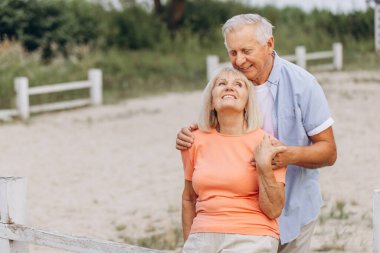 Gülümseyen son sınıf çifti, parkta gün boyu kucaklaşıp eğleniyorlar. Çift birbirinin yanında mutlu ve mutlu görünüyor..