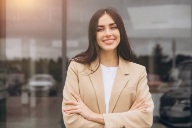 Bej ceketli mutlu kadın müşteri el ele tutuşarak katlanmış araba galerisi galerisi galerisi galerisinde yeni otomobil almak istiyor..