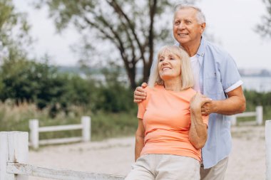 Gülümseyen son sınıf çifti, parkta gün boyu kucaklaşıp eğleniyorlar. Çift birbirinin yanında mutlu ve mutlu görünüyor..