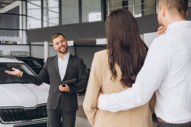 Otomobil Showroom 'daki İş Yeri' nde Güzel Araba Satıcısı 'nın Portresi, Yeni Otomobil, Ücretsiz Alan Almak İçin Eşlere Ellerinde Pano Veren Genç Satış Müdürü