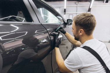 Close up to PPF installation process on a side car door. PPF is a Paint Protection Film which protect paint from scratches and stone chips. Concept of: Guard, Protect, Car, New, Work. clipart