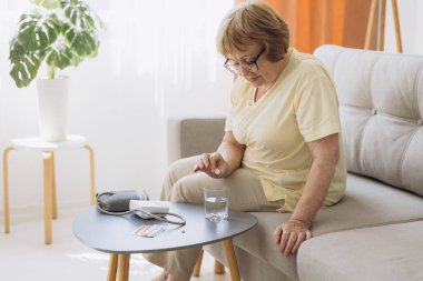 Yüksek tansiyonu olan yaşlı bir kadın evinde bir bardak suda eritilmiş bir hap içmek ister.