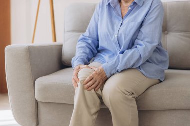 Vücut eklem iltihabı kas sertliği, bacak ağrısı, kronik hastalıktan dolayı diz ağrısı, el masajı, eklem masajı sakatlığı, evdeki koltukta oturan yaşlı ya da ağrılı yaşlı kadın..