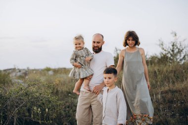 Neşeli bir aile birlikte güzel zaman geçirir, huzurlu bir arazide yürürler. Görüntü, aşkı, birlikteliği ve doğanın güzelliğini rahat bir ortamda yakalar..