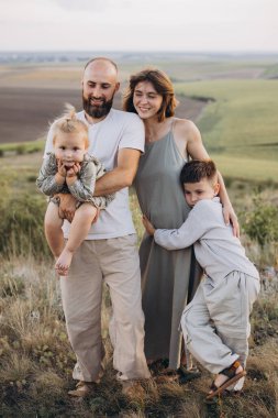 Neşeli bir aile, açık hava ortamında birlikte vakit geçirir. Sevgi, sıcaklık ve mutluluk gösterirler. Aile bağı ve doğa keyfi için mükemmel bir tema..