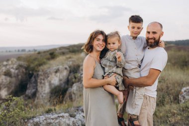 Dört kişilik neşeli bir aile, güzel bir kırsal alanda birlikte neşeli bir anı paylaşıyor. Aşk, birliktelik ve doğa temaları için mükemmel..