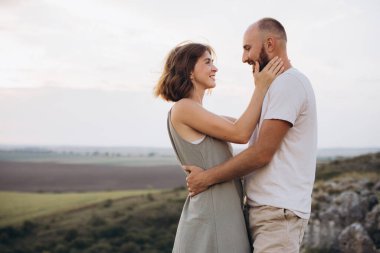 Sevgi dolu bir çift, güzel bir kırsal alanda samimi bir anı paylaşıyor. Bu içten kucaklaşmada neşe, romantizm ve mutluluğu yansıtıyorlar..