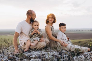Dört kişilik neşeli bir aile gün batımında manzaralı bir tepede birlikte vakit geçiriyorlar. Doğada sevgi ve beraberlik anları yakalıyorlar..