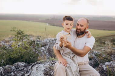 Bir baba ve oğul dışarıda kayaların üzerinde oturur, oyuncak bir uçakla meşgul olur, hayal gücünü teşvik eder ve doğada güneşli bir günde bağ kurarlar..