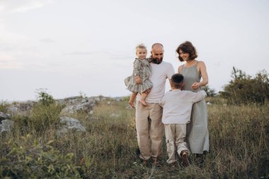 Dört kişilik neşeli bir aile birlikte dışarıda güzel bir çayırda vakit geçiriyorlar, sevgi, birlik ve doğa temalarını aktarıyorlar..