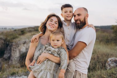 Dört kişilik neşeli bir aile güzel bir açık hava ortamında birlikte vakit geçiriyorlar. Mutluluk ve beraberlik yayıyorlar. Doğadaki aile birliği ve sevginin özünü yakalar..
