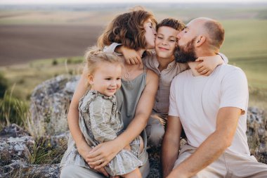 Neşeli bir aile, güzel bir açık havada, sevgi ve mutluluğu paylaşarak kaliteli zaman geçirir. Barışçıl bir ortamda aile bağının mükemmel bir temsili..