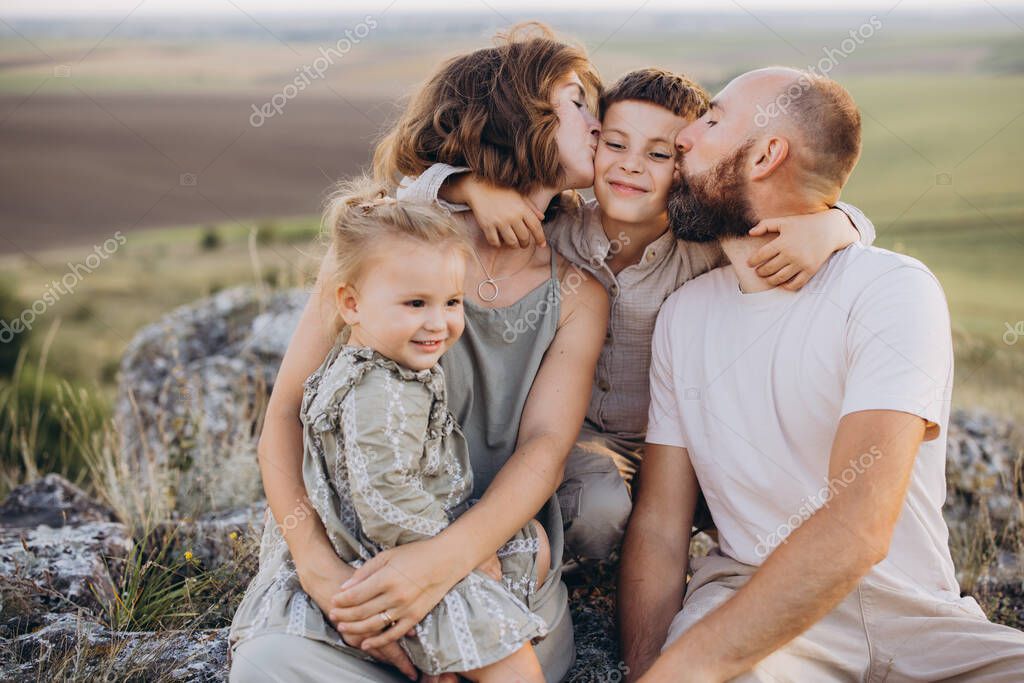 A joyful family spending quality time together in a picturesque outdoor setting, sharing love and happiness. Perfect representation of family bonding in a peaceful nature setting.