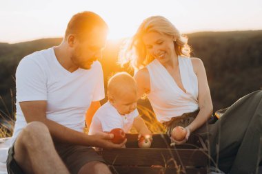 Neşeli bir aile gün batımında sakin bir açık hava pikniği yaşıyor. Doğayla iç içe yaşayan, sevgi, mutluluk ve birlikteliği ön plana çıkaran ebeveynler..