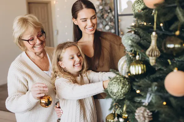 Üç nesildir bir Noel ağacını birlikte süsleyen neşeli bir aile sahnesi sıcaklığı, sevgiyi ve şenlik ruhunu yakalıyor. Gülümseyen kadınlar ve çocuklar evde büyülü bir tatil bağı kuruyorlar..