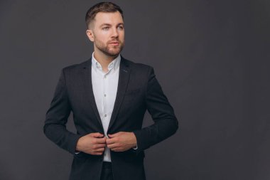 Bin yıllık beyaz iş adamı gri stüdyo arka planında izole edilmiş, resmi takım elbiseli başarılı bir adam.