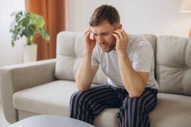 Depresyondaki umutsuz adam zihinsel çöküntü, psikoterapi, pankart boyunca kanepede yatar.