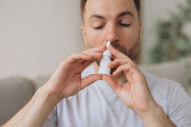 Hüsrana uğramış sağlıksız, hasta, alerjik bir adamın kırmızı gözleri var. Alerji yüzünden burnu akıyor. Semptomlar yüzünden.