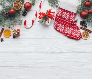 Noel kompozisyonu. Hediyeler, çam kozalakları, köknar dalları, şeker, baharatlar ve ahşap beyaz arka plandaki diğer süslemeler. Düz yatış, üst görünüm.