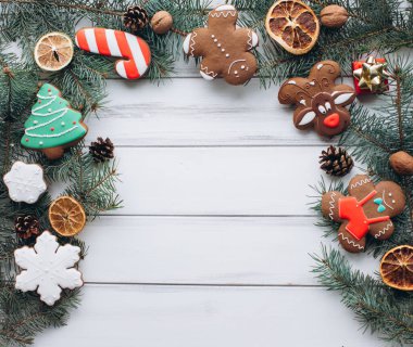 A festive arrangement of decorated Christmas cookies, pine cones, and dried oranges on a rustic wooden background. Perfect for capturing the holiday spirit and warmth of a Christmas celebration. clipart