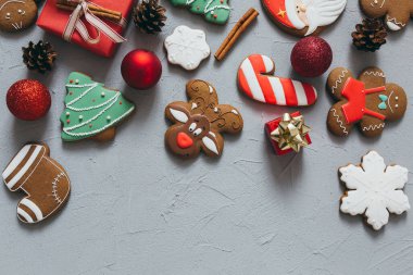 Gri bir arka planda Noel kurabiyesi, baharat ve süslemeler..