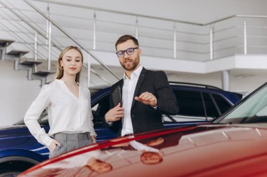 Araba Satış Müdürü, Kafkasyalı Kadın Alıcıya Otomobil Galerisinde Otomobil Gösteriyor. Araç Konsepti Alınıyor