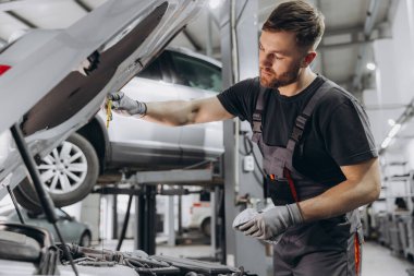 Tamirci, servis merkezindeki motor yağı seviyesini kontrol ediyor.