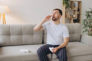 Hüsrana uğramış, sağlıksız, hasta, alerjisi olan adamın kırmızı gözleri var. Burnu akıyor, burnu ağrıyor. Alerji belirtileri var.