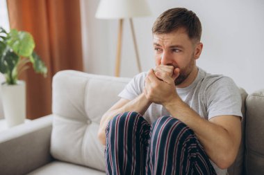 Depresyondaki umutsuz adam zihinsel çöküntü, psikoterapi, pankart boyunca kanepede yatar.