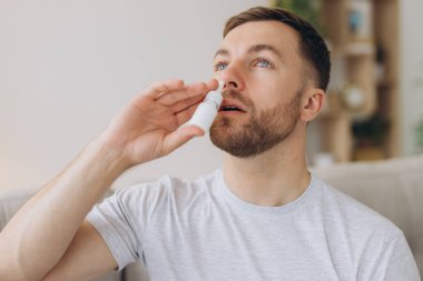 Hüsrana uğramış sağlıksız, hasta, alerjik bir adamın kırmızı gözleri var. Alerji yüzünden burnu akıyor. Semptomlar yüzünden.
