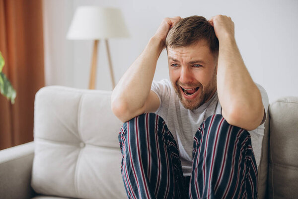 депрессивный безнадежный мужчина в домашней одежде лежал на диване во время психического срыва, психотерапии, баннер