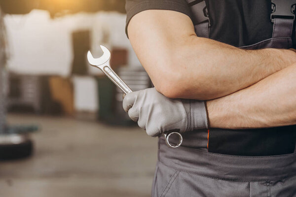 Car care maintenance and servicing, Close-up hand technician auto mechanic holding the wrench to repairing change spare part and fix car engine problem or car insurance service support concepts.