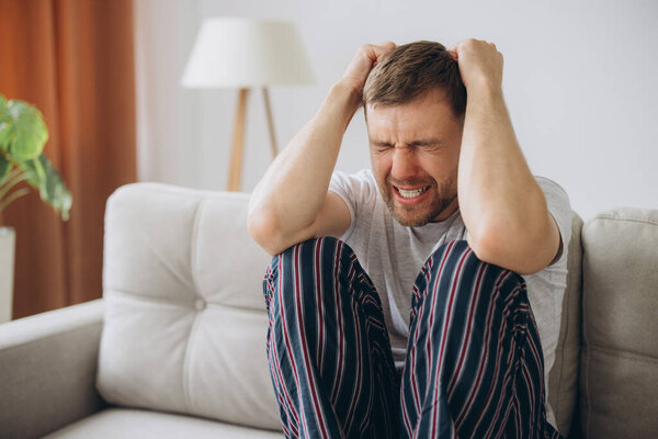 депрессивный безнадежный мужчина в домашней одежде лежал на диване во время психического срыва, психотерапии, баннер