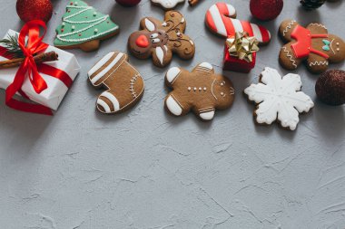Gri bir arka planda Noel kurabiyesi, baharat ve süslemeler..