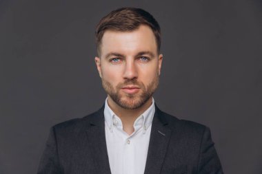 Kafkasyalı milenyum işadamı, gri stüdyo gerisinde izole edilmiş.